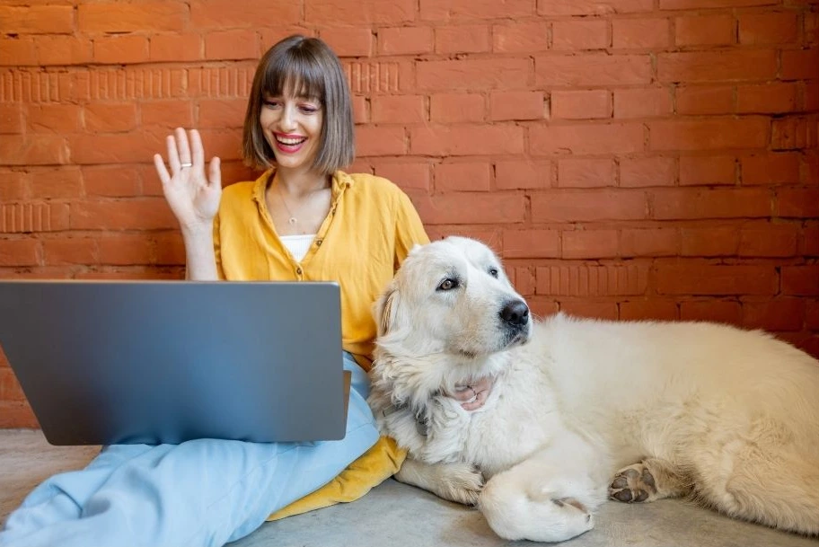 A woman training her dog online using a virtual training programfrom Maiak9